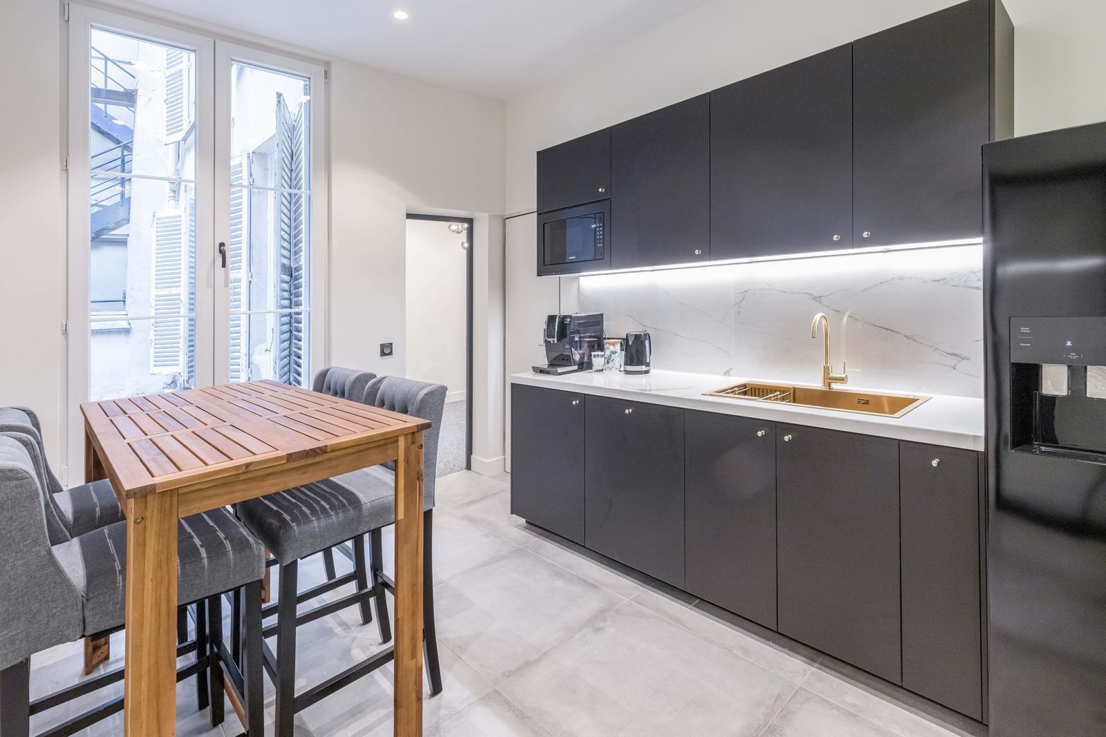 Cuisine équipée avec table haute et frigo américain